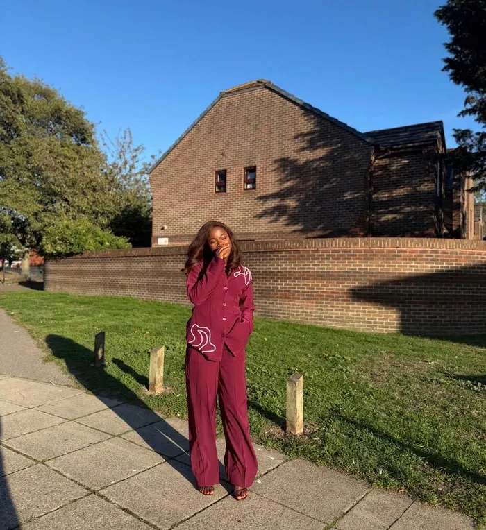 Precious in a burgundy suit on a sunlit path