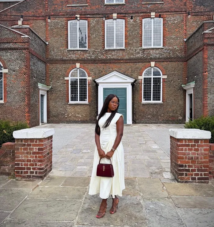 Precious in an ivory dress in a brick courtyard